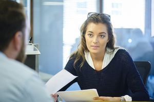 a woman talking to someone in an office