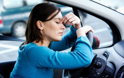 她的汽车的疲乏的妇女。