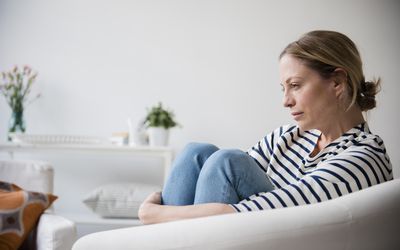 坐在扶手椅子的白种人妇女拿着腿