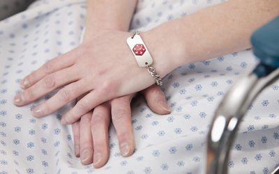 女患者手与医疗身份手镯的特写