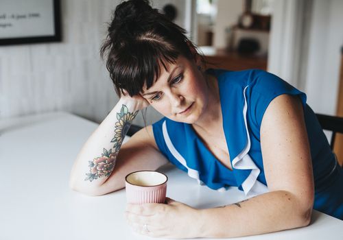 woman-looking-depressed-while-holding-a-cup-of-coffee