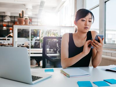 年轻的商人使用移动电话在工作