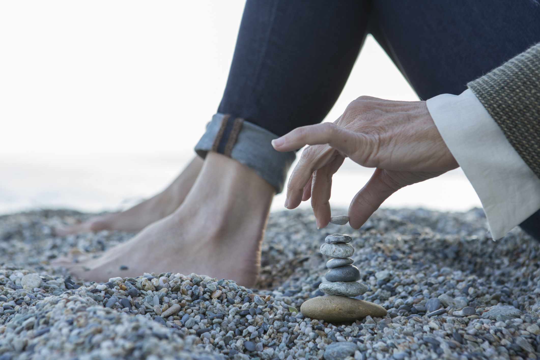 女人堆石头在沙滩上