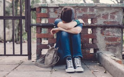 郁闷的少女坐在地上捂着脸