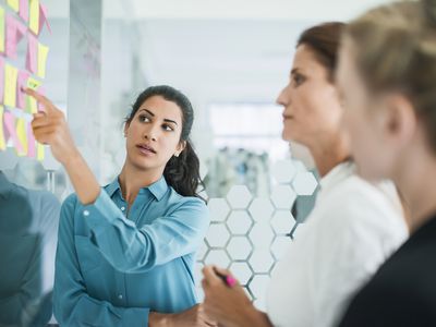 三个女人在墙上的贴纸前头脑风暴