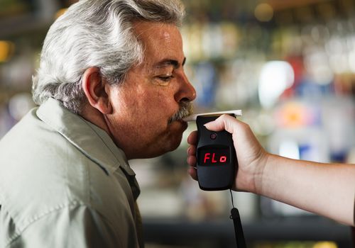 man blowing into breathalyzer test