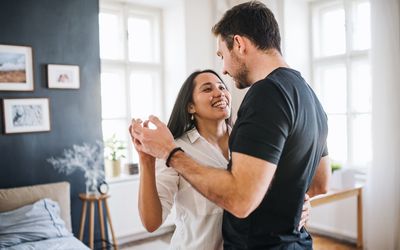 在爱跳舞的深情的年轻夫妇在家跳舞，获得乐趣