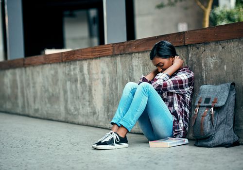 女学生坐在校外的地板上