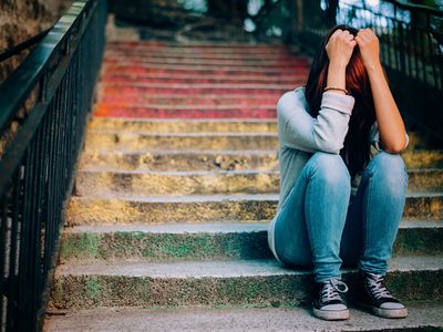 妇女坐与头的步在她的手上