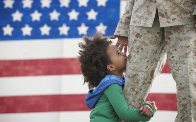 返回的士兵的黑人女孩抱着腿