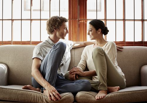 Loving couple siting on sofa at home