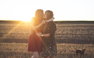 亲吻在一个领域的两名妇女在日落