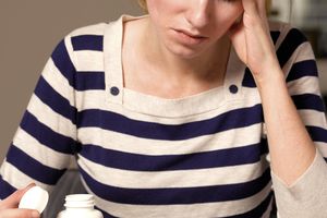 模型姿势作为看药瓶的妇女