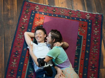 两个女人在地板上的地毯上拥抱