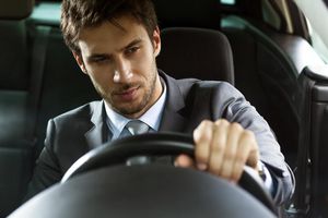 一个英俊的年轻商人近距离驾驶汽车