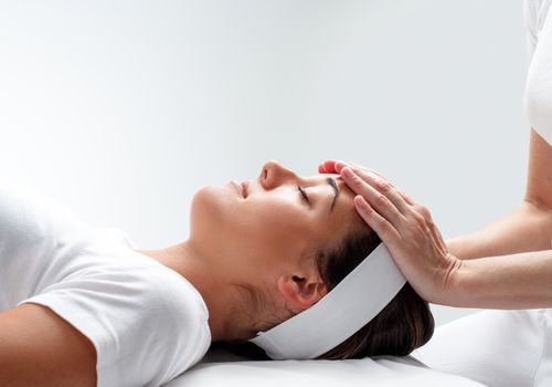 Woman relaxing at reiki session.