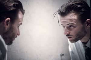 沉思的男人看着镜子