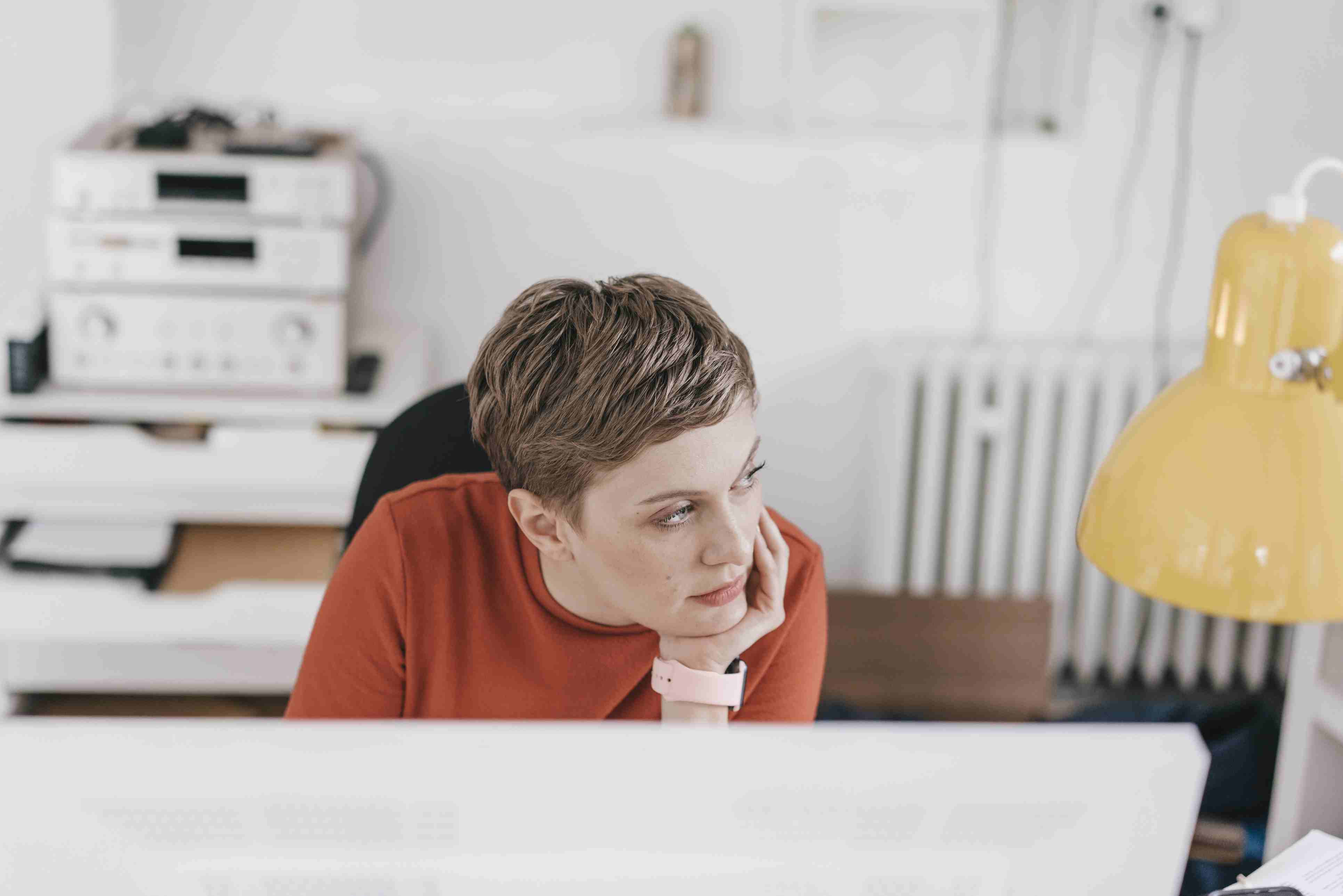 Woman at desk in office thinking