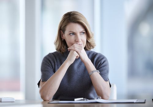 Pensive businesswoman looking away in conference room