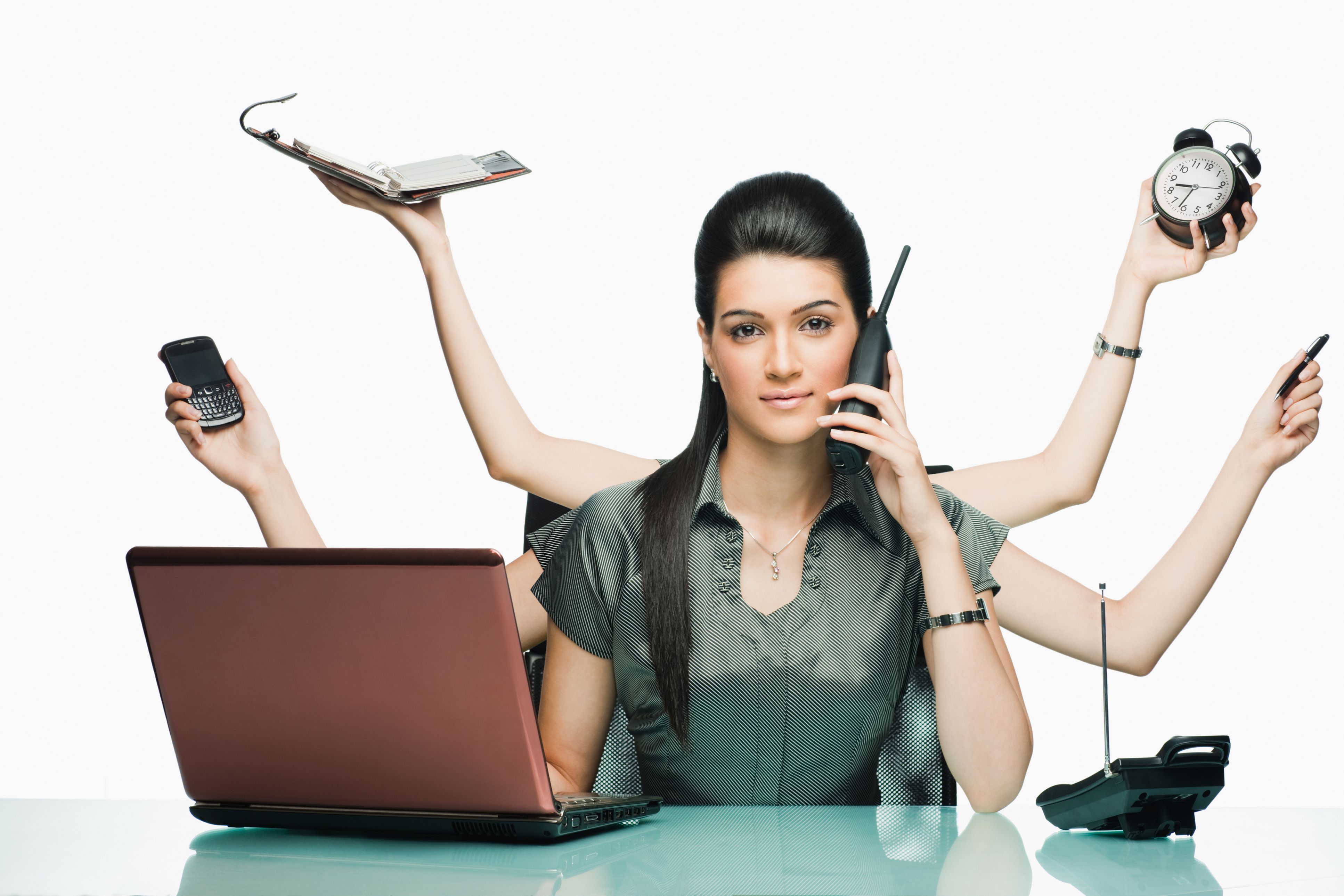多臂握着无绳电话、使用笔记本电脑、时钟、记事本、笔和其他设备的女人