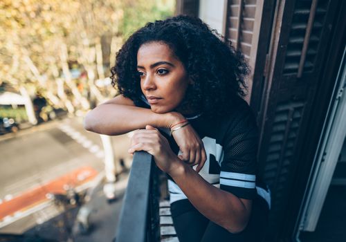 Sad BIPOC woman looking out the winddow