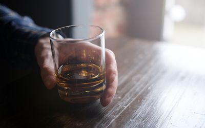 拿着杯威士忌酒的人