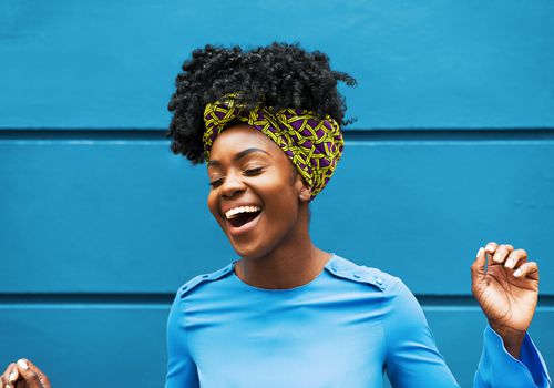 Joyous woman in front of wall