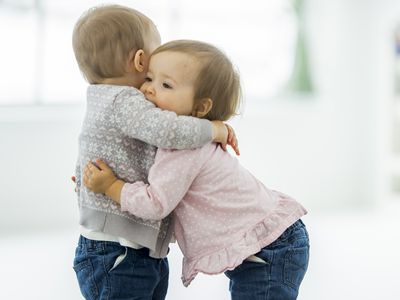 两名双胞胎女婴在一起玩耍和在日托上拥抱