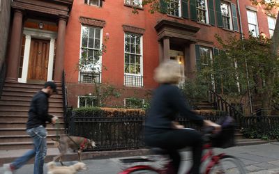 Pedestrians walking along the perimeter of Washington Square Park