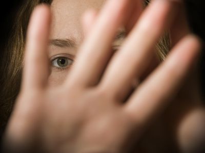 女人用手挡住相机