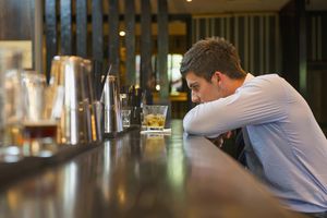 young man drinking at bar alone