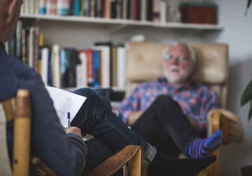 A man, sitting in a chair, talking to his psychiatrist