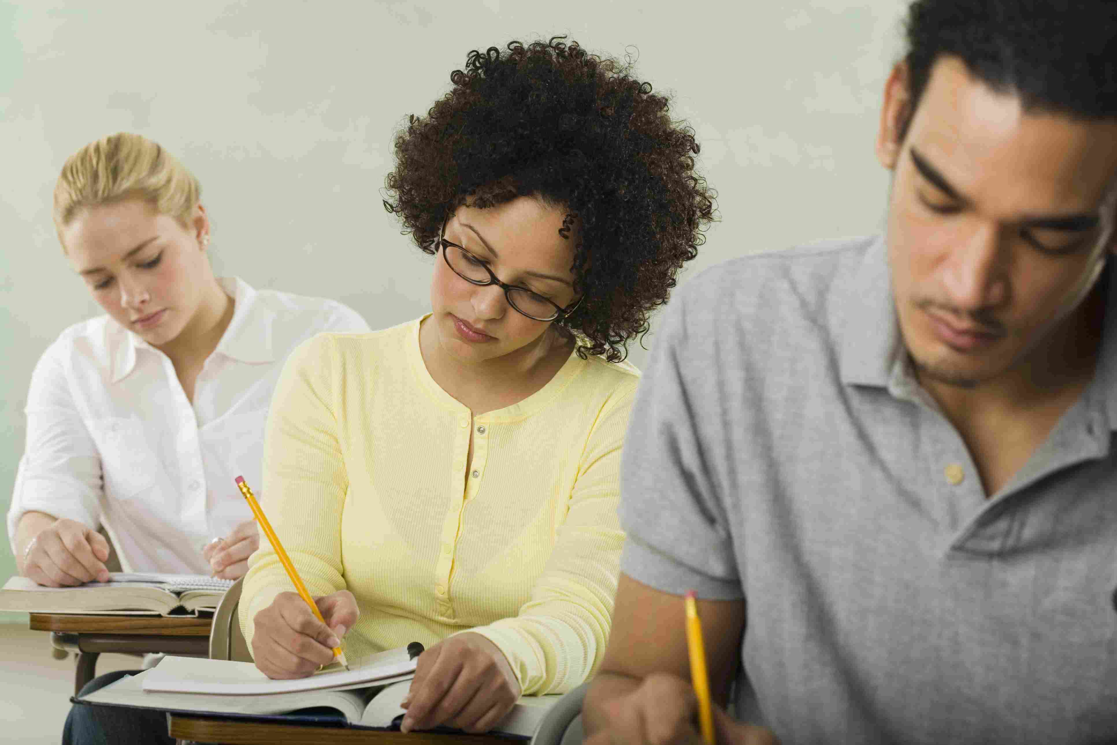 Three students taking a test in a classroom