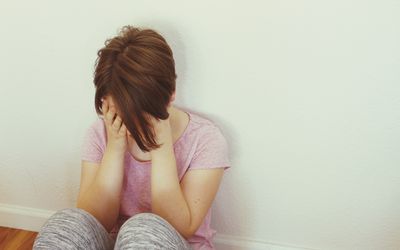 妇女坐与头的地板在她的手上