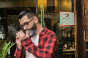 有禁烟令的男子在酒吧外吸烟