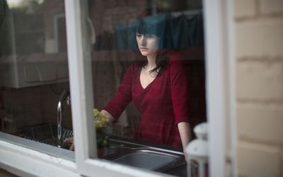 站立在厨房里的哀伤的妇女