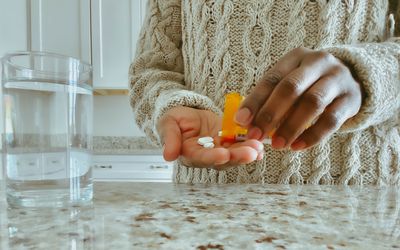 女人把药片倒入她的棕榈