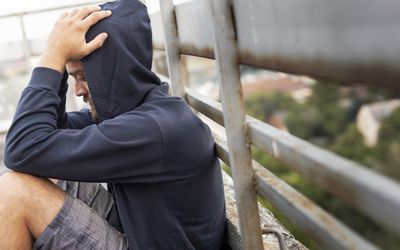 手抱头坐着的人