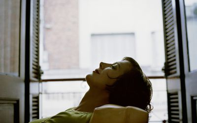 一名妇女躺在有她的眼睛的椅子闭上了。