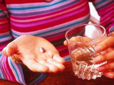 拿着药片和水的妇女