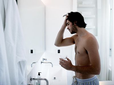 Man rubbing head in bathroom