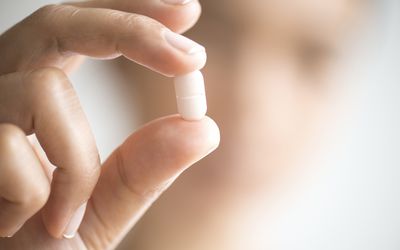 A woman holding a pill