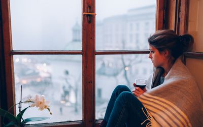 坐在窗口附近的沮丧的妇女