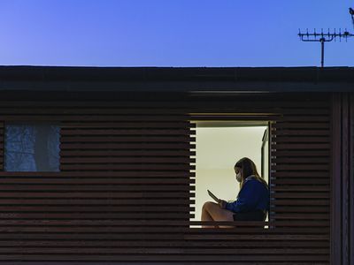 girl sitting alone on her laptop wearing a mask