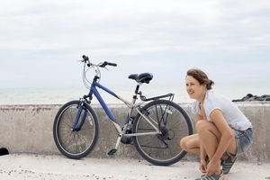 在自行车旁系鞋带的女人