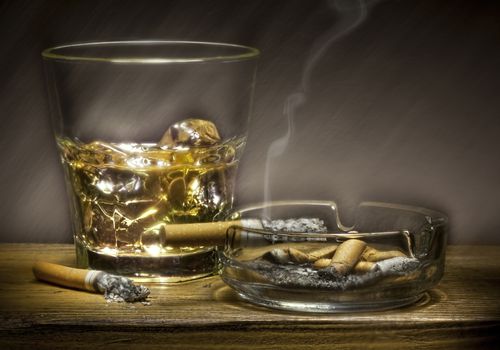 威士忌酒杯和烧焦的香烟