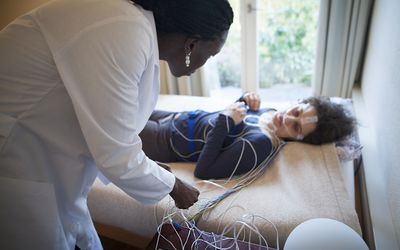 女人被连接到睡眠研究仪器上