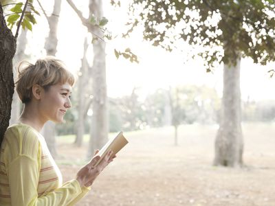 日本妇女阅读书在公园