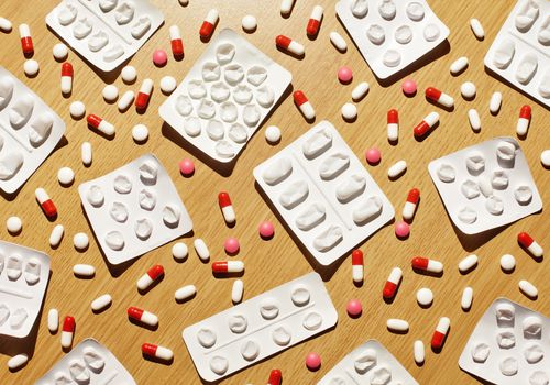 Loose pills and pill packs scattered on a table