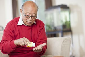 senior asian man taking medication